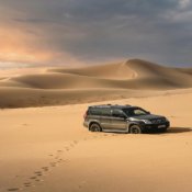 Car driving through the Dubai desert during a safari tour, representing the exciting adventures available with the best tourist agency for Dubai tours.